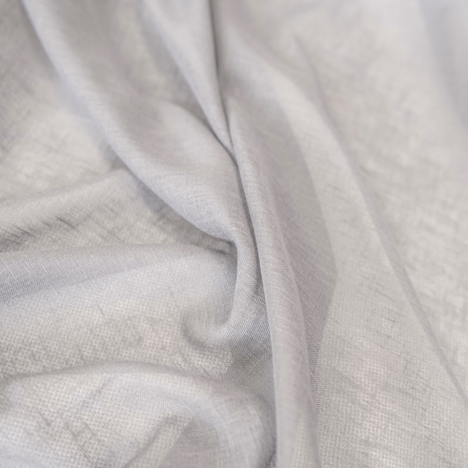 Pale ash-grey finely woven textile draped in soft folds with subtle tonal texture