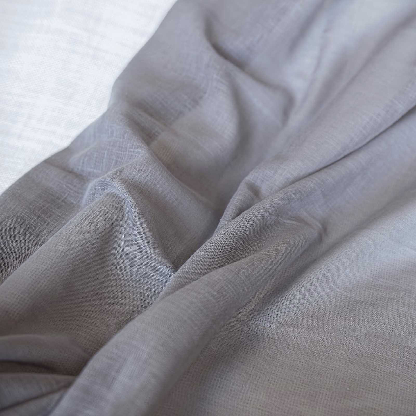 Cool silver-grey Andros Mercury fabric showing fine crosshatch weave and softly gathered folds
