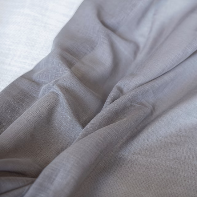 Cool silver-grey Andros Mercury fabric showing fine crosshatch weave and softly gathered folds