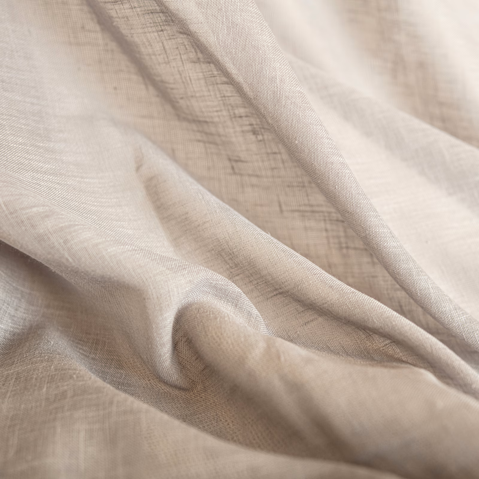 Warm ivory-beige woven fabric softly gathered, showing fine crosshatch texture and fluid folds.