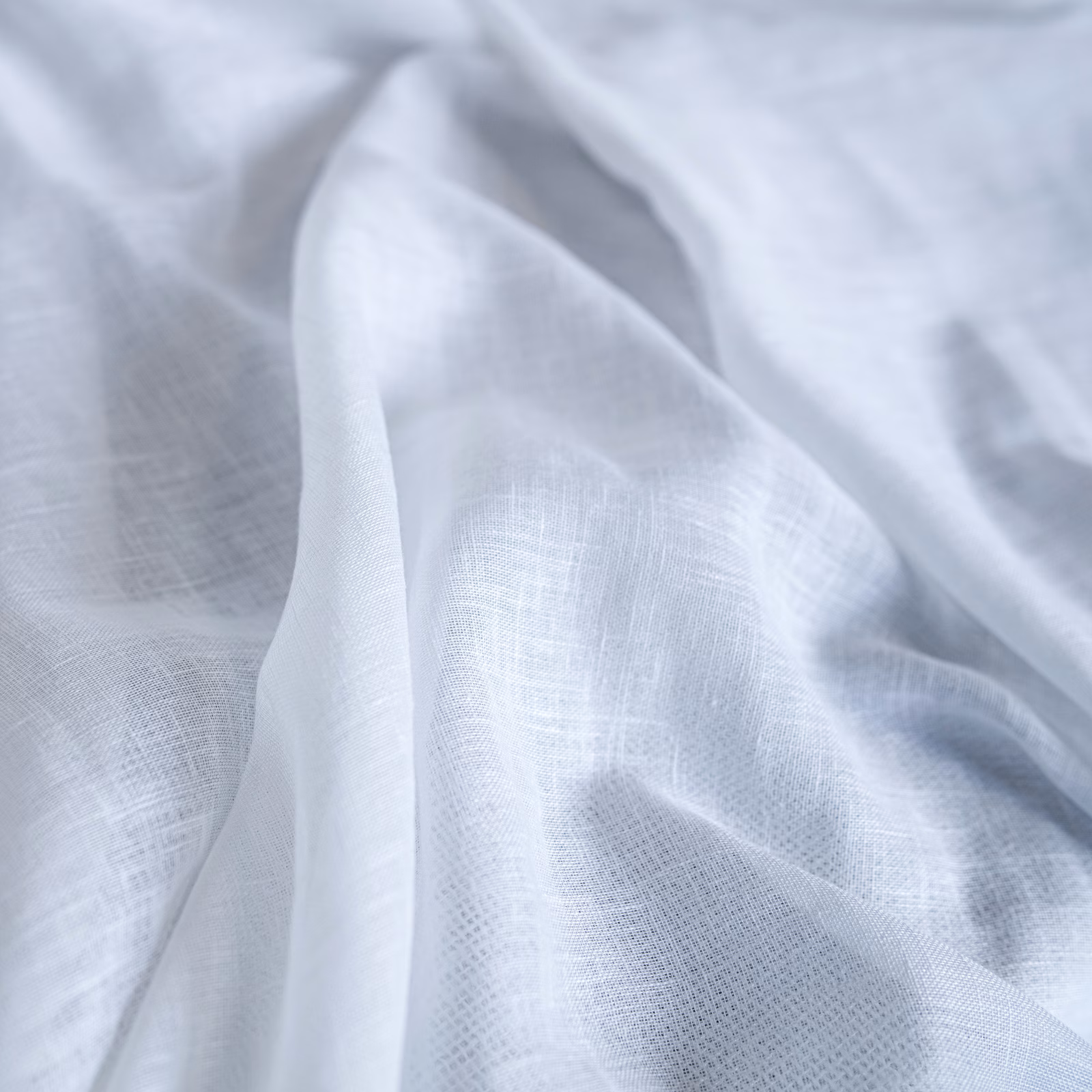 Icy blue-white finely woven fabric draped in translucent, softly folded layers