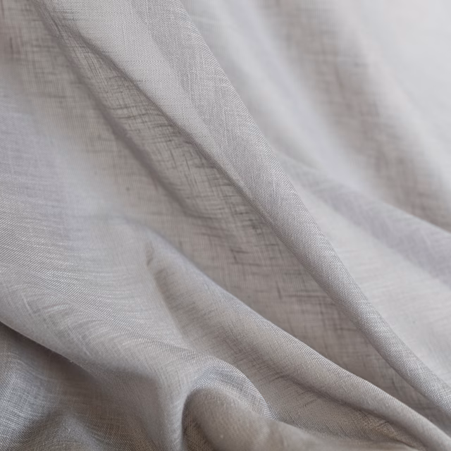 Pale pebble-taupe woven textile with a fine open weave in layered folds
