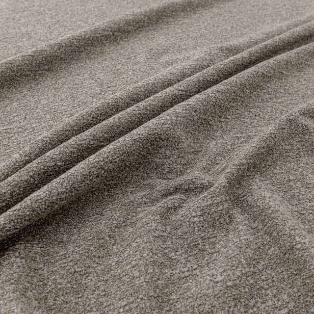 Warm fawn-grey textured fabric folded into soft diagonal ridges