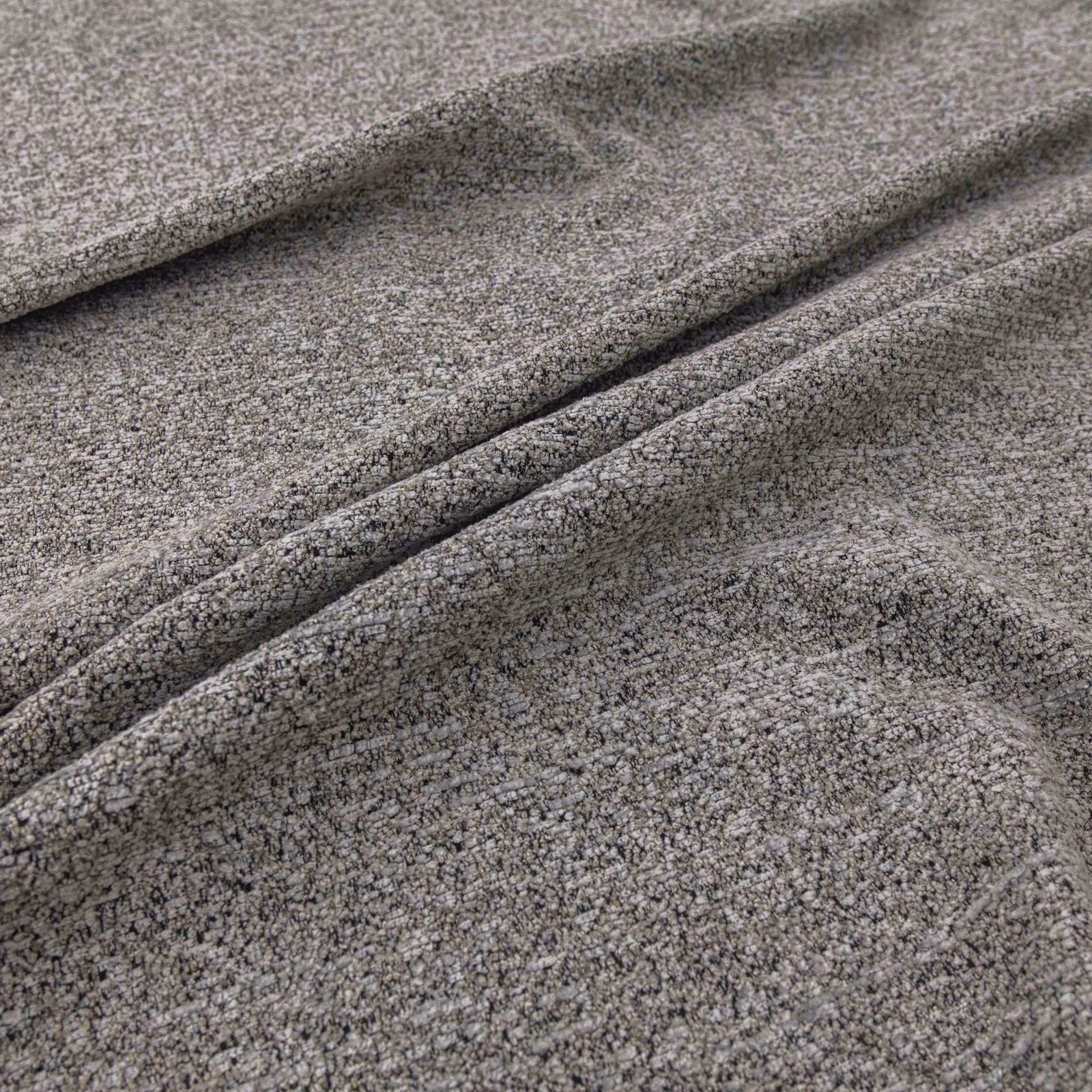 Close-up of cool mottled grey fabric with dense nubby weave folded into soft ridges