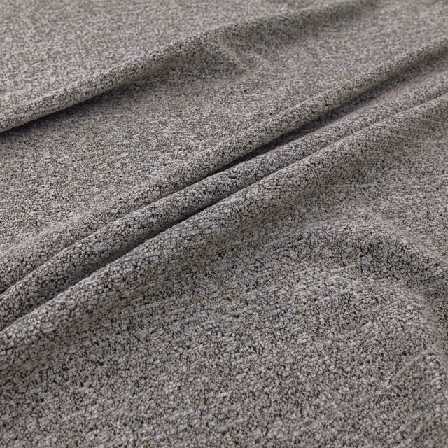 Close-up of cool mottled grey fabric with dense nubby weave folded into soft ridges