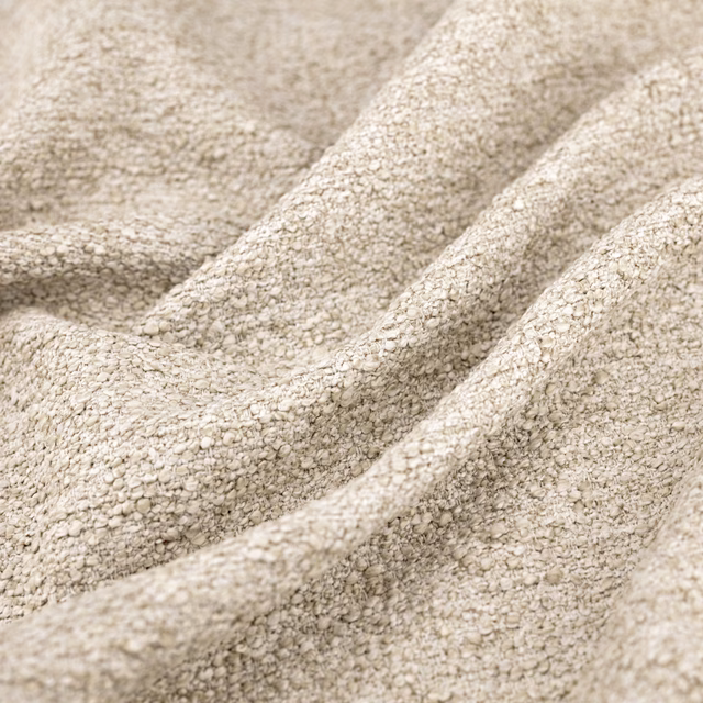 Warm ecru woven fabric with chunky flecks and deep draped folds