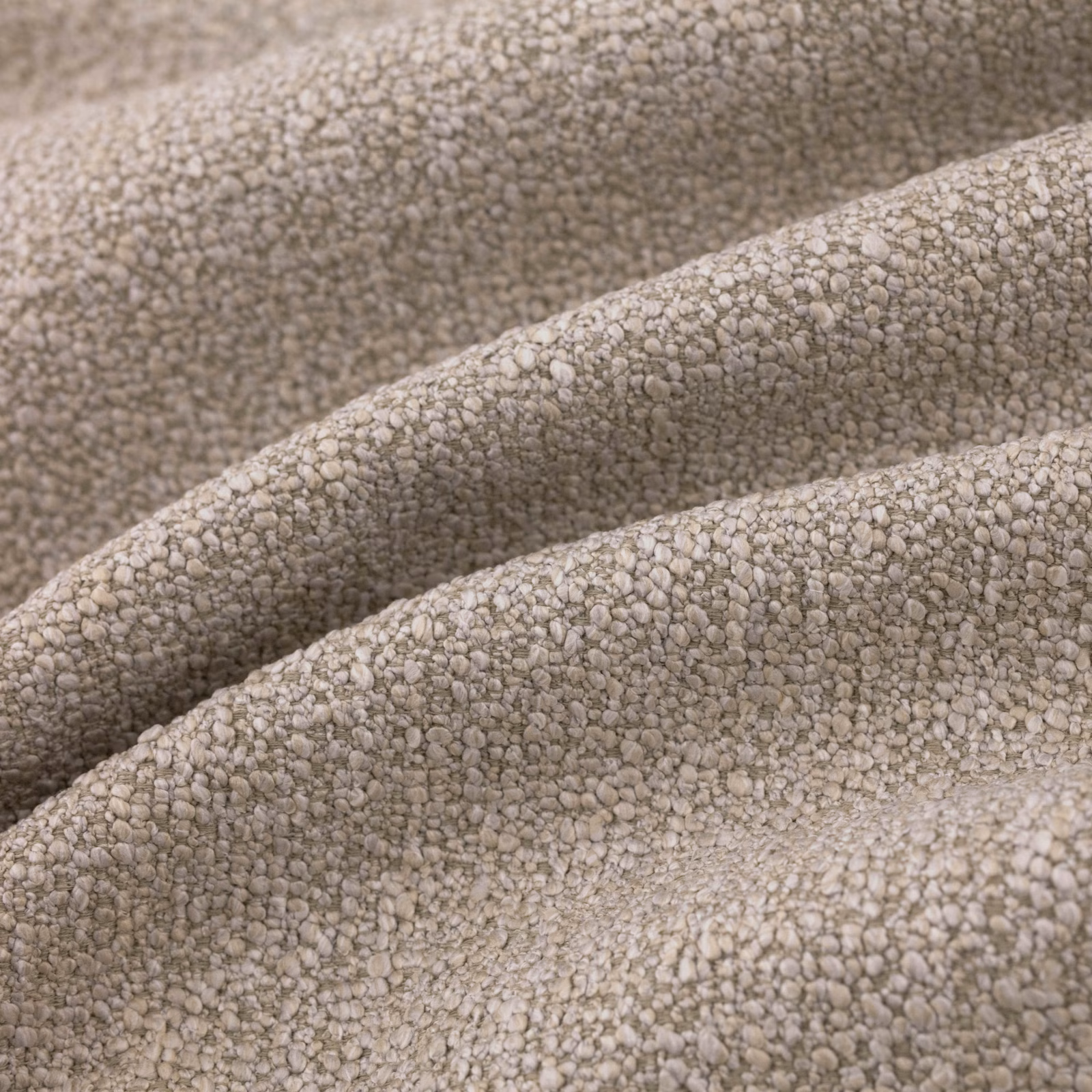 Warm taupe pebble-textured fabric draped in softly shadowed folds