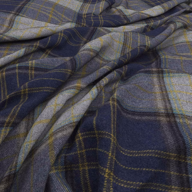 Deep indigo plaid fabric with blue-grey blocks and muted olive lines in soft folds