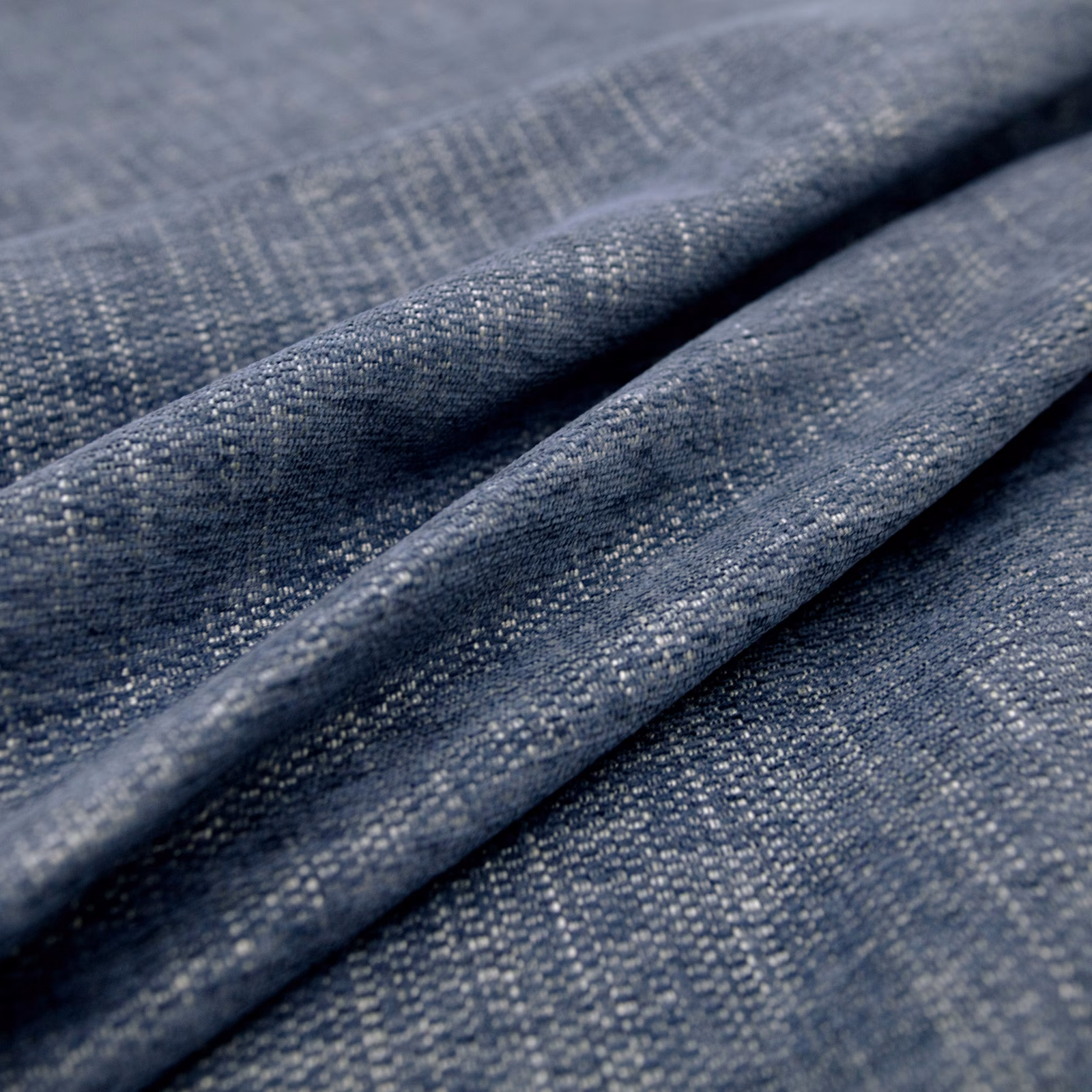Close-up of folded grey-flecked indigo fabric with a fine woven crosshatch texture