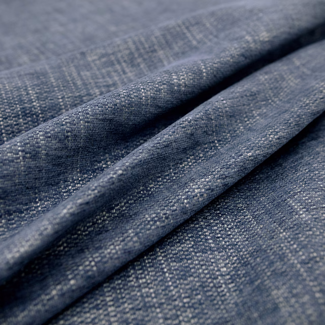 Close-up of folded grey-flecked indigo fabric with a fine woven crosshatch texture