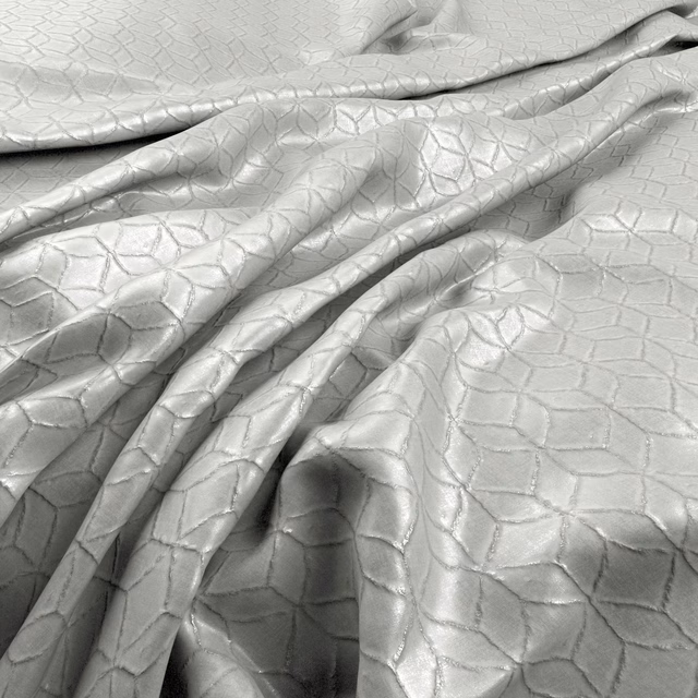 Pale silver-grey fabric with raised irregular geometric cells and gentle sheen