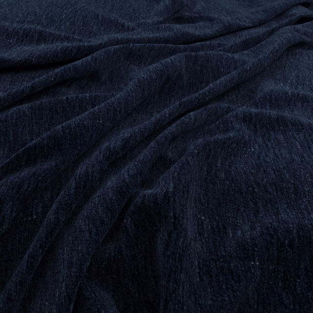 Deep denim-blue plush pile fabric gathered into softly reflective folds