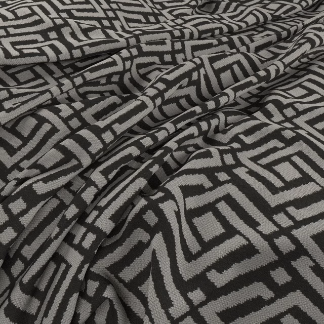 Charcoal and stone-grey woven fabric with bold interlocking geometric lines and soft folds