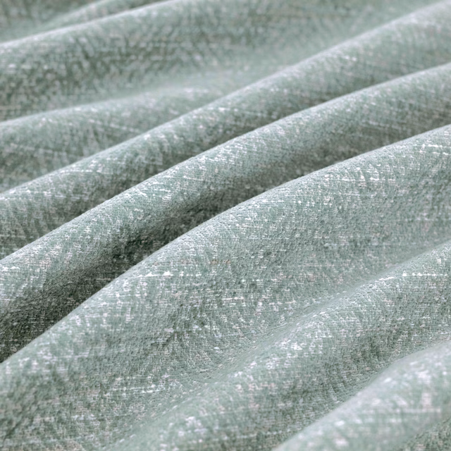 Pale sage-green Boutin Delft textile with softly flecked weave draped in broad folds