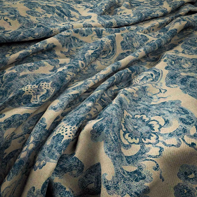 Teal and beige Persian floral fabric with paisley motifs in soft folds