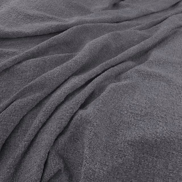 Deep charcoal-grey fabric with fine brushed texture falling into soft diagonal folds