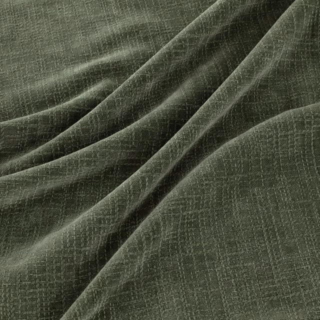 Muted sage-green crosshatched weave gathered into softly lit fabric folds