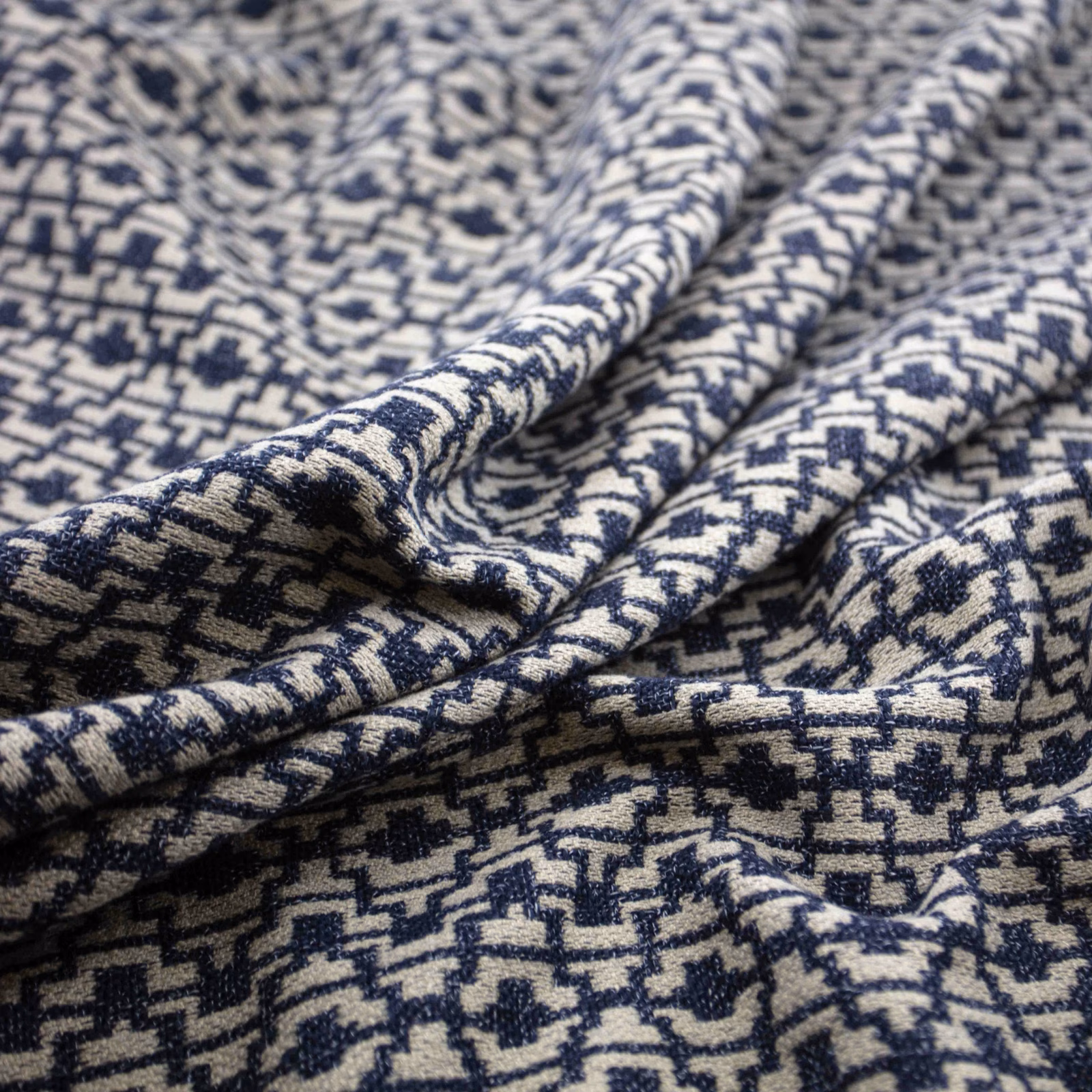 Deep ink navy and cream geometric woven fabric with a nubby, folded texture
