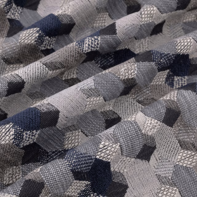 Folded indigo, charcoal and grey geometric woven textile with raised textured blocks