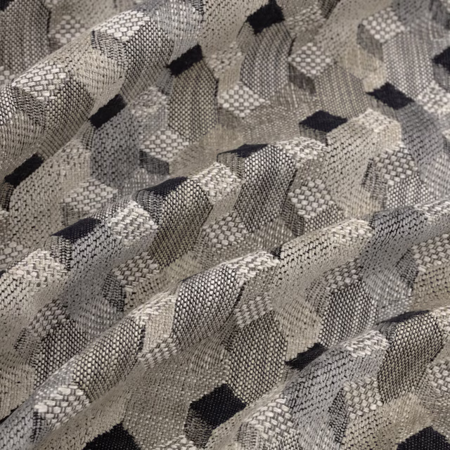 Close-up of a woven geometric fabric in soft grey, cream and charcoal tones