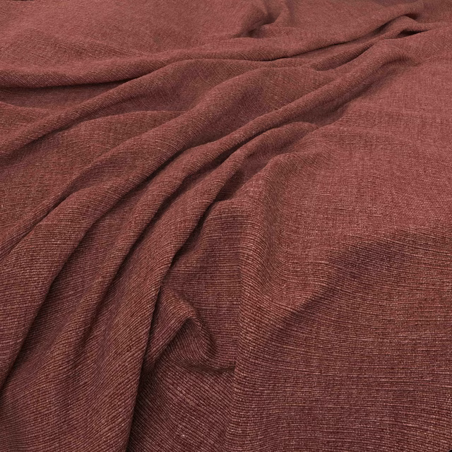 Muted berry-burgundy woven fabric with fine horizontal grain and soft draped folds