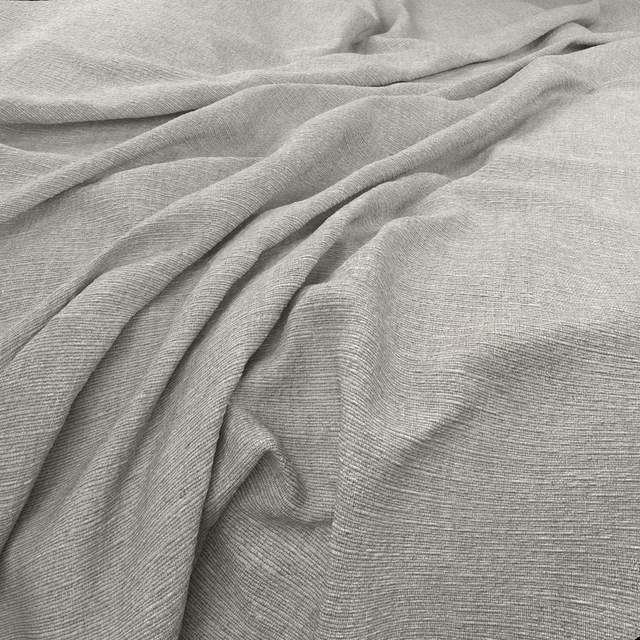Pale cool-grey finely textured fabric gathered into soft, fluid folds