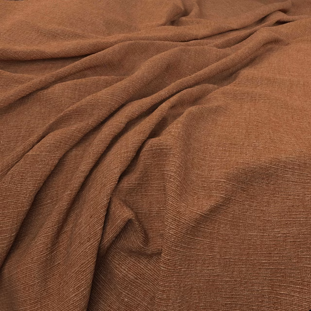 Warm kiln-brown fabric with fine horizontal ribbing arranged in soft draped folds