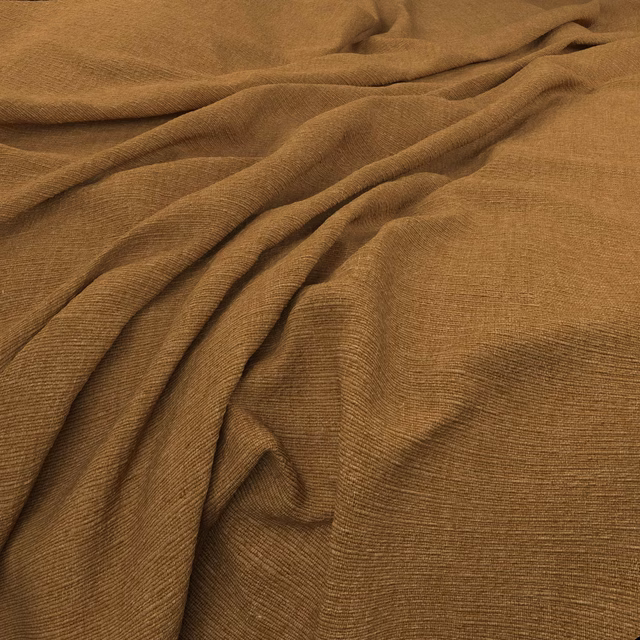 Warm saffron-brown ribbed fabric gathered into soft, flowing folds