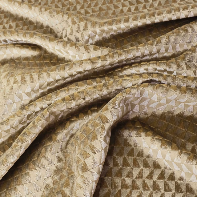 Warm gold geometric textile with ivory triangles and taupe-brown shadows in folded cloth