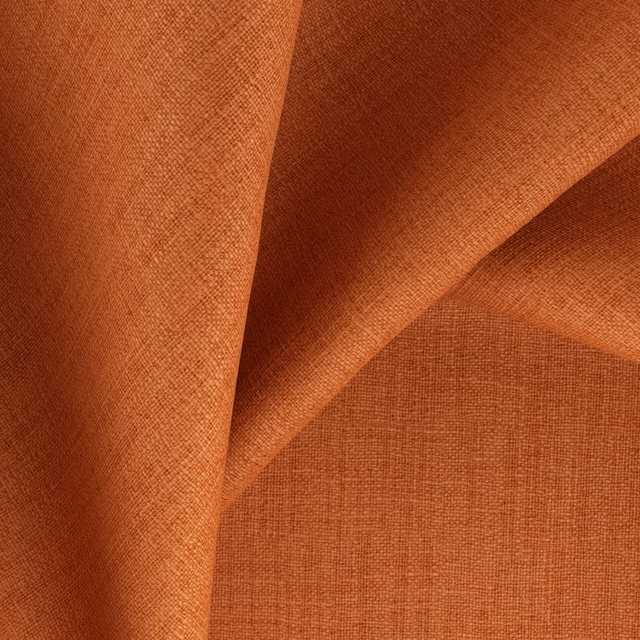 Warm henna terracotta fabric showing a fine crosshatch weave across folded cloth