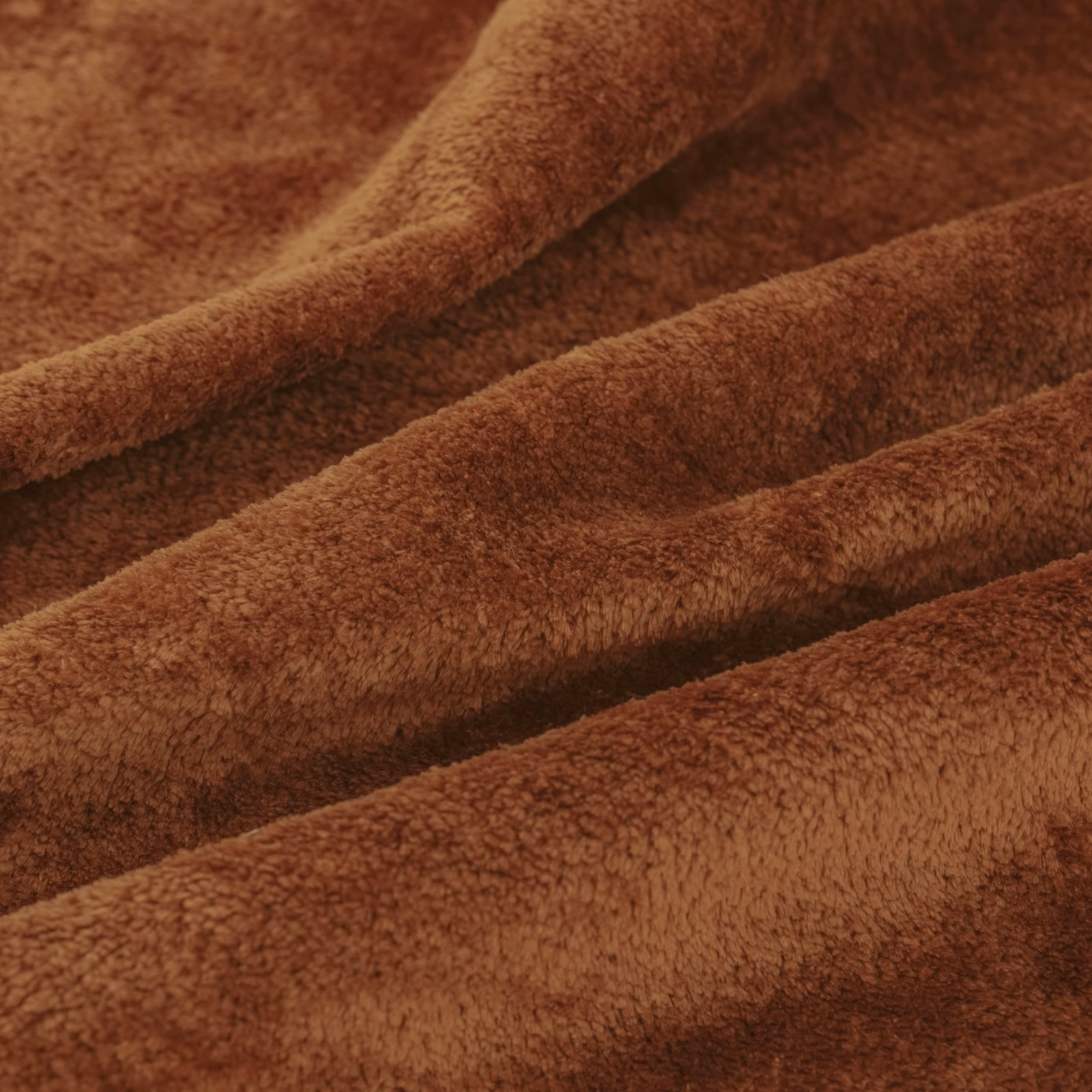 Close-up of warm burnt-brown dense pile folded into soft ridges