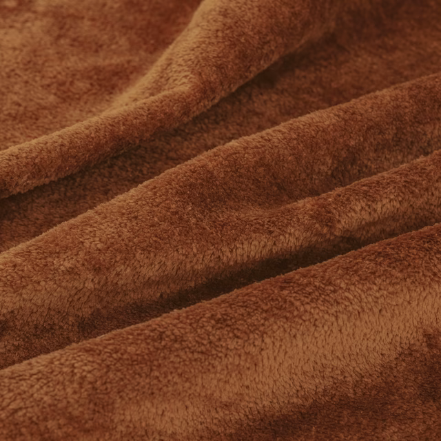 Close-up of warm burnt-brown dense pile folded into soft ridges
