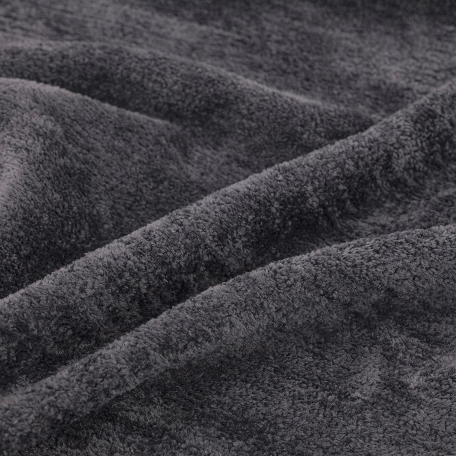 Deep charcoal-grey plush pile fabric gathered into softly shadowed folds