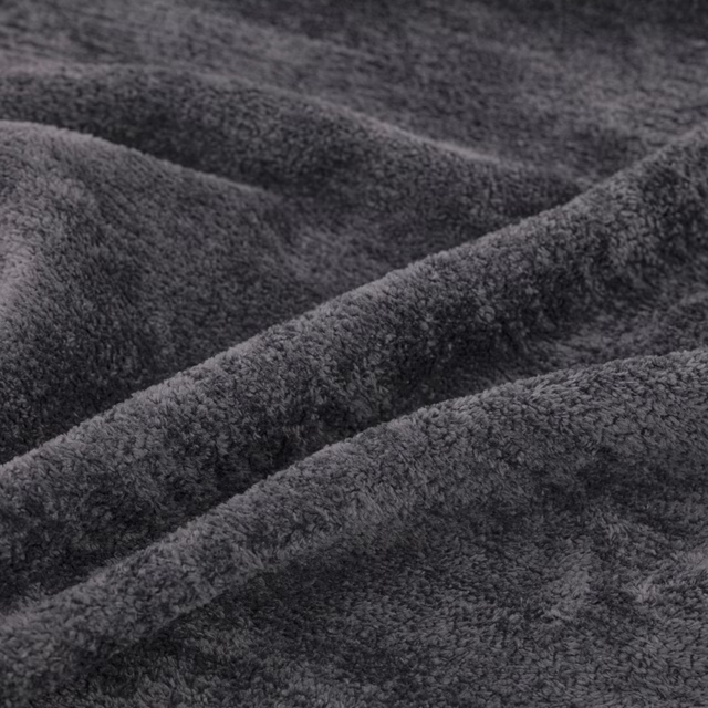 Deep charcoal-grey plush pile fabric gathered into softly shadowed folds