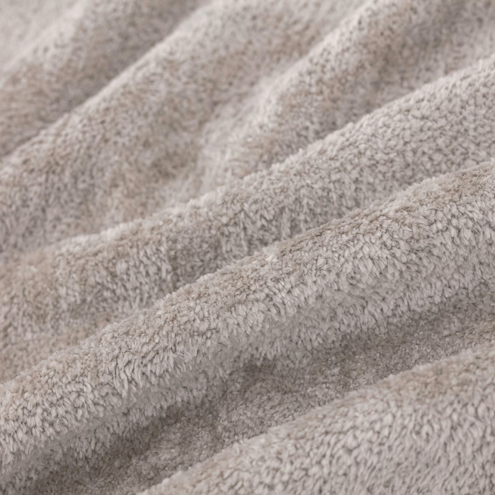 Close view of pale dove-grey nubby pile forming softly shadowed textured folds
