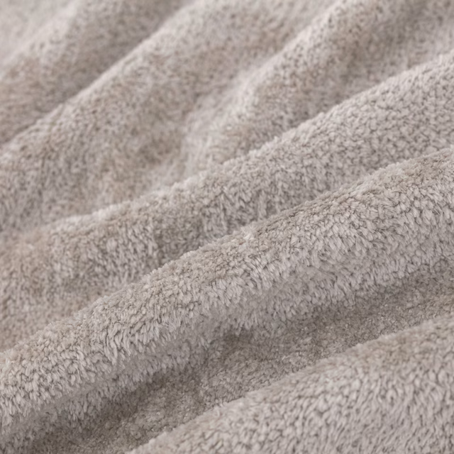Close view of pale dove-grey nubby pile forming softly shadowed textured folds