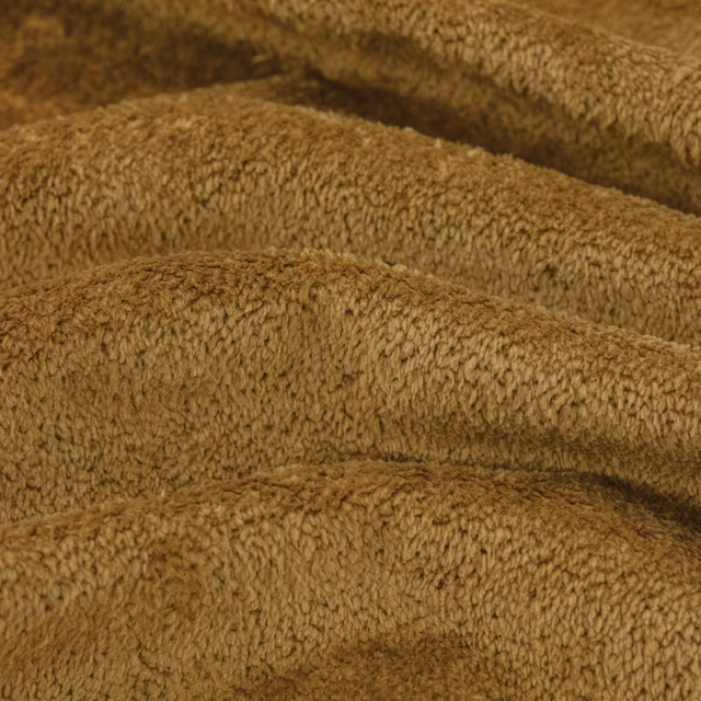 Warm honey-brown bouclé upholstery swatch with dense looped pile and folded tonal shading