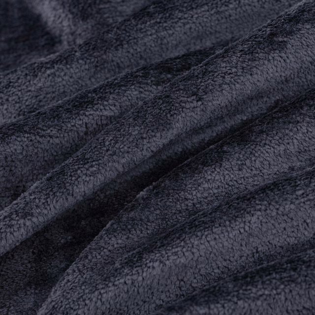 Near-black indigo fabric with dense nubby pile folded into softly shaded ridges