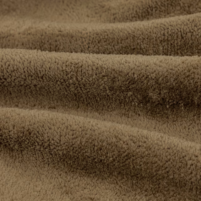 Close-up of warm lichen-taupe fabric with dense curled plush pile and shadowed ridges