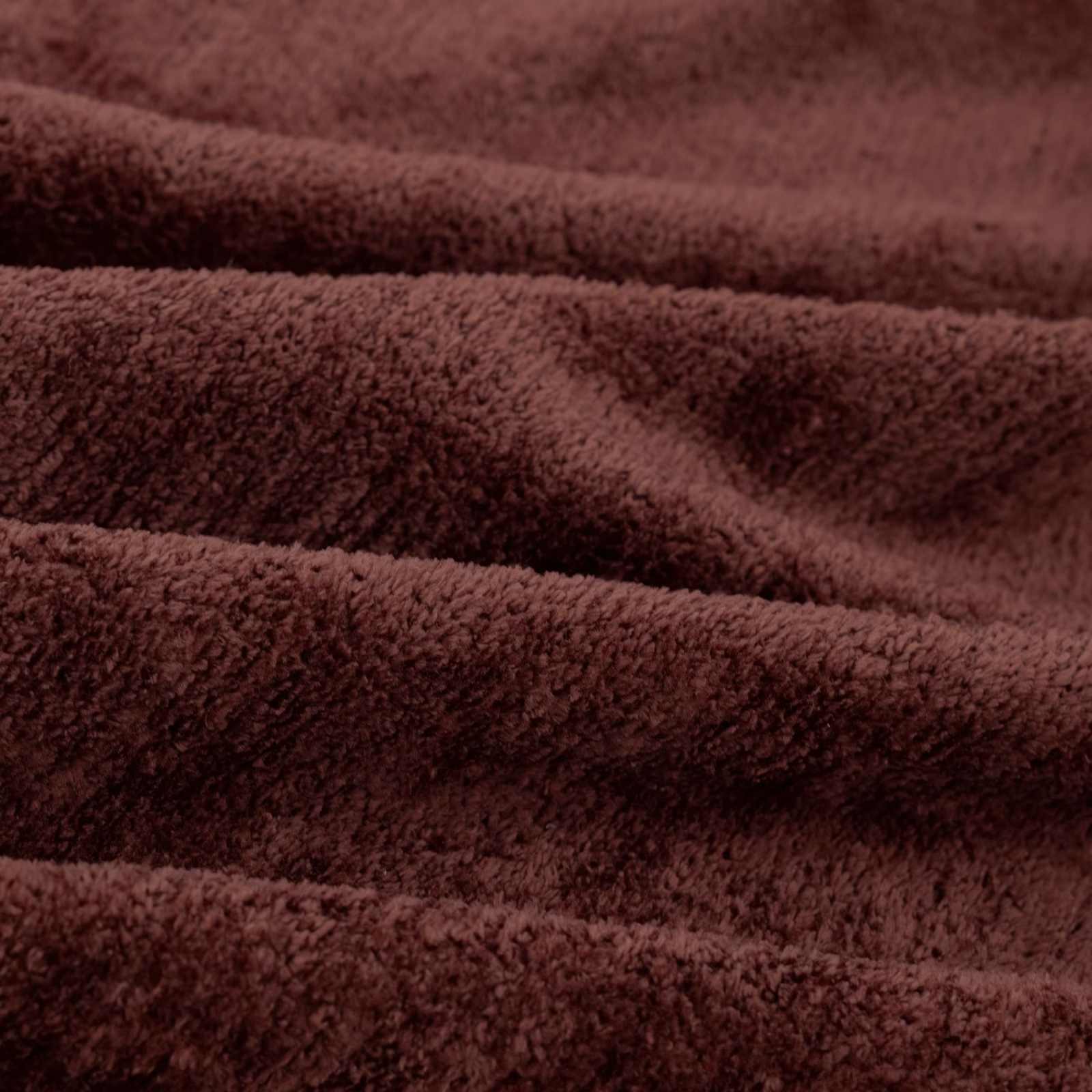 Deep russet-brown plush fabric showing dense pile and shadowed folded texture