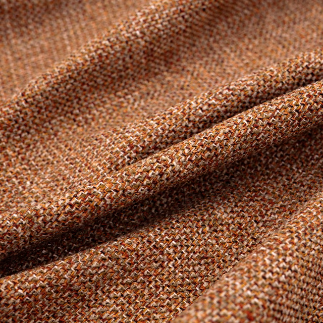 Close-up of warm terracotta brown woven fabric with cream and rust flecks