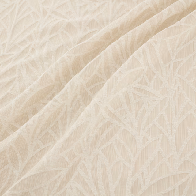 Warm ivory woven fabric with raised angular leaf motifs and softly textured folds