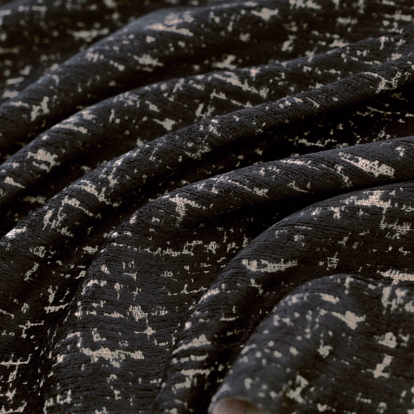 Gathered black woven fabric with irregular pale flecks and pronounced textured folds
