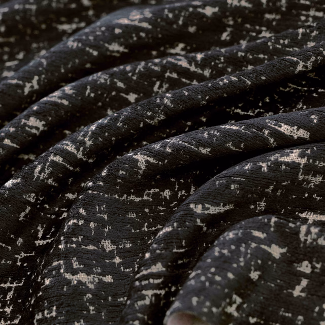 Gathered black woven fabric with irregular pale flecks and pronounced textured folds