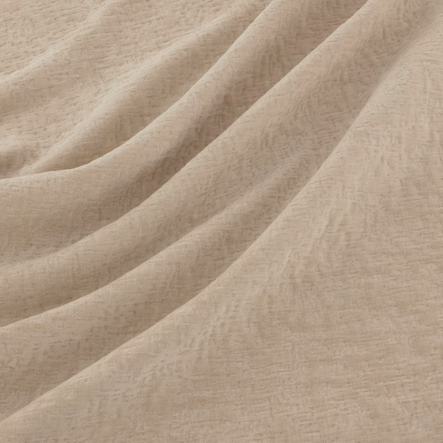 Warm ecru fabric with softly mottled texture falling in broad fluid folds
