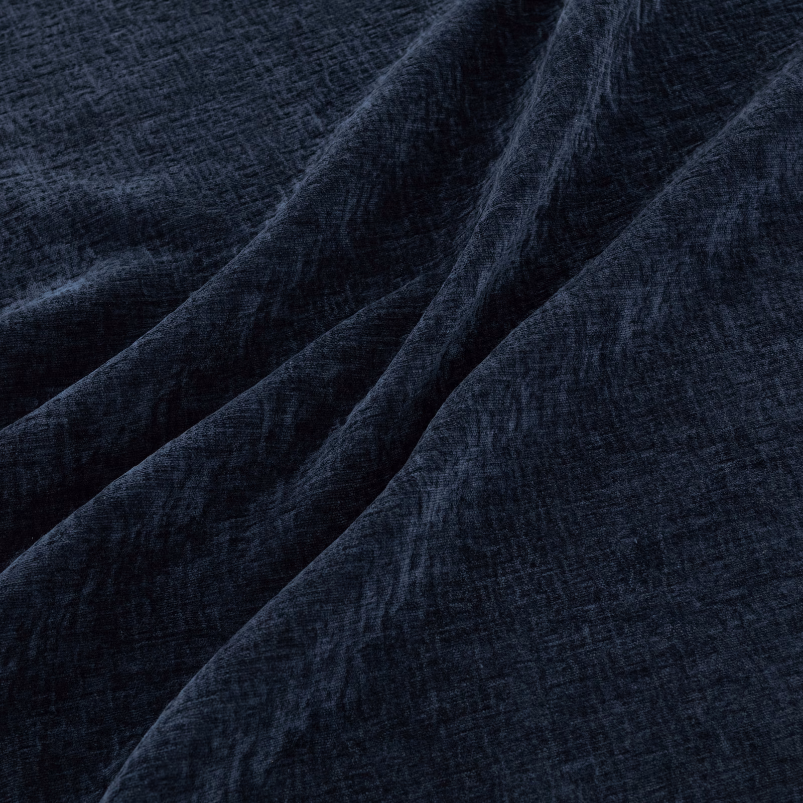 Near-black indigo woven textile with brushed texture and deep diagonal folds