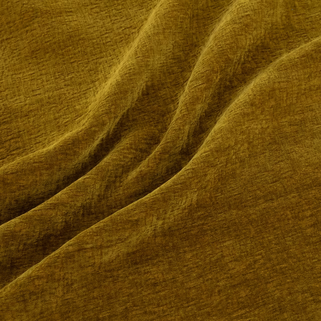 Warm ochre-gold fabric with softly brushed texture and deep draped folds