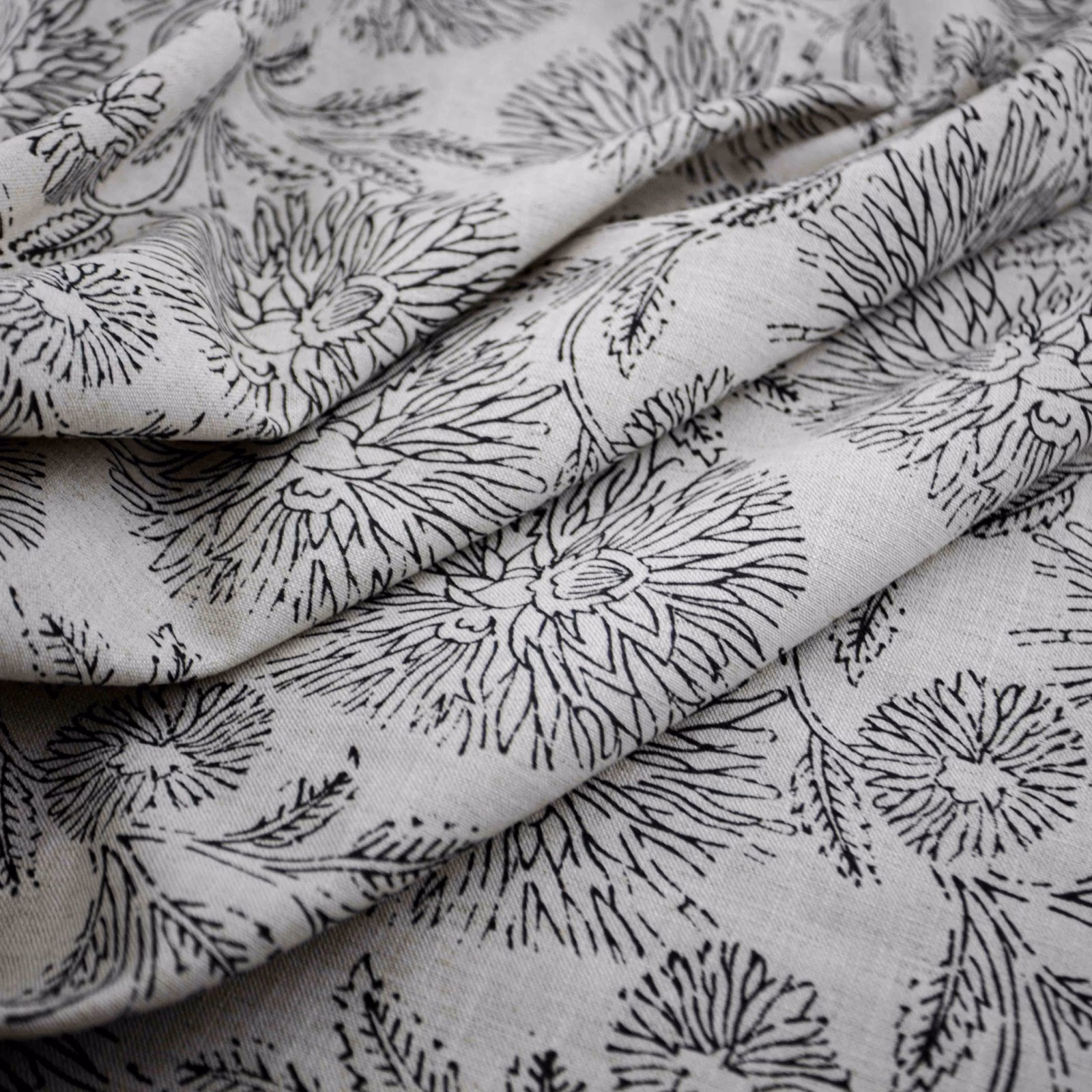 Soft grey floral fabric with black sketch-like blooms and visible woven texture