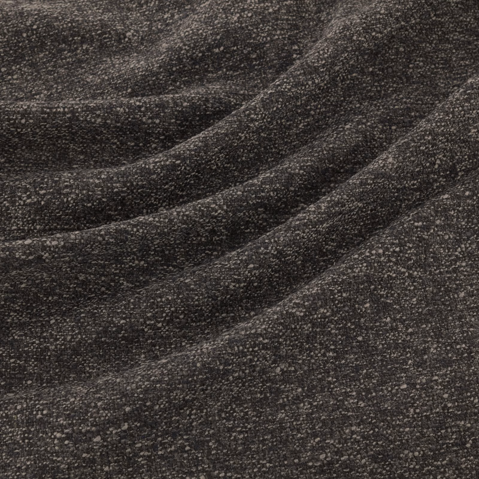 Close-up of charcoal grey flecked weave forming soft diagonal folds