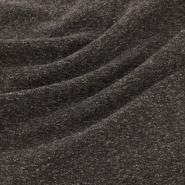 Close-up of charcoal grey flecked weave forming soft diagonal folds
